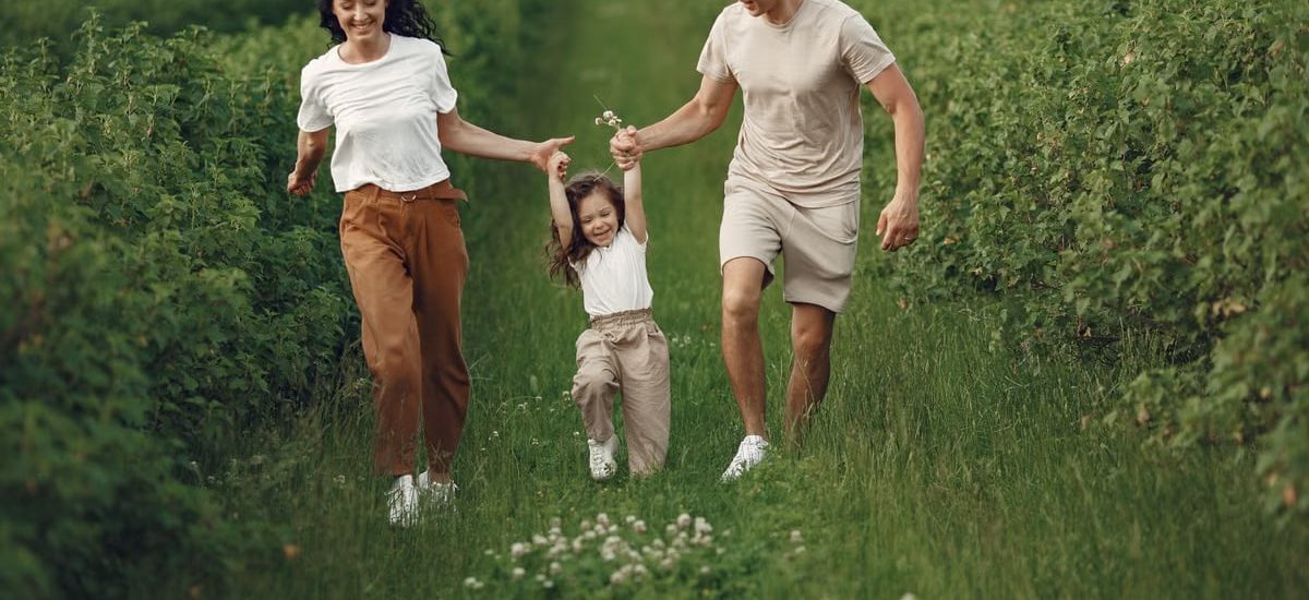 Joyful family enjoying a fun day outdoors in a green field, epitomizing togetherness and happiness.