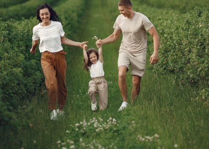 Joyful family enjoying a fun day outdoors in a green field, epitomizing togetherness and happiness.